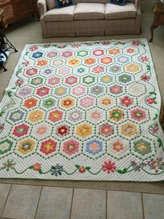 a living room filled with furniture and a white rug covered in flowers on the floor