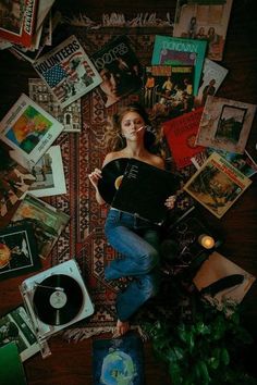 a woman laying on top of a rug covered in books