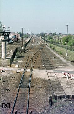 an empty train track with no cars on it in the middle of a rural area