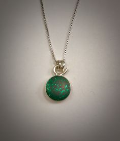 This sterling silver necklace has a tiny emerald green glitter resin pendant. The pendant itself is approximately 3/4 of an inch long by 1/2 of an inch wide. It is on a 16 inch box chain. Other chain lengths are available upon request. I have 16, 18, &20 inch chains. Just send me a convo. This necklace can be duplicated Green Jewelry With Silver Chain As Gift, Green Charm Necklace With Round Pendant And Adjustable Chain, Green Charm Necklace With Adjustable Round Pendant, Green Sterling Silver Charm Necklace For May Birthstone, Green Pendant Jewelry With Silver Chain, Green Nickel-free Oval Pendant Necklace, Green Sterling Silver Charm Necklace, Green Sterling Silver Oval Pendant Necklace, Green Nickel-free Pendant Charm Necklace