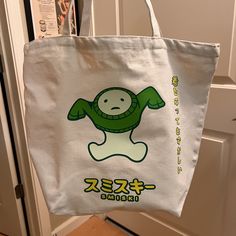 a white bag with a green cartoon character on it