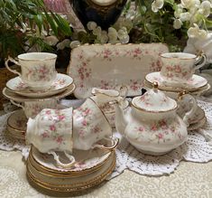 a table topped with lots of white and pink dishes