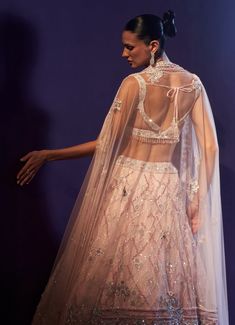 This exquisite Pink Multi-Colour Sequins Embroidered Bridal Lehenga Set is a stunning example of intricate craftsmanship and timeless elegance. Crafted from soft net fabric, the flowing pink lehenga is adorned with multi-colored sequins, crystals, and bugle beads, creating a shimmering effect that dances with the light, adding a touch of magic to every step. Teamed with matching blouse is equally breathtaking, featuring delicate embroidery that harmonizes perfectly with the lehenga’s design. Completed this opulent ensemble with a sheer dupatta, embellished with floral motifs, which adds an ethereal, graceful touch. Ideal for the bride or bride-to-be, this lehenga set offers a flawless blend of traditional beauty and contemporary flair, ensuring that you shine with sophistication and style Embroidered Bridal Lehenga, Sheer Dupatta, Traditional Beauty, Pink Lehenga, Delicate Embroidery, Net Fabric, S Design, Bugle Beads, Bridal Lehenga