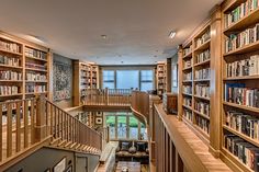 the stairs are made of wood and have bookshelves on each side, along with many other shelves