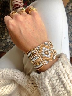 a close up of a person's hand wearing two different bracelets