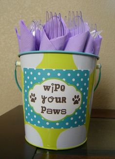 a bucket filled with purple plastic forks sitting on top of a table