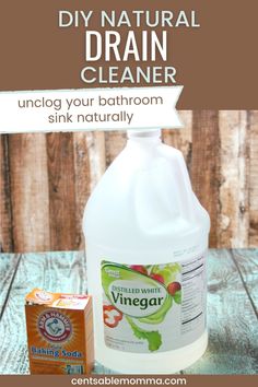 a bottle of vinegar cleaner next to a carton of vinegar on a wooden table