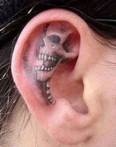 an ear with a skull tattoo on it