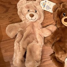 two teddy bears laying on the floor next to each other