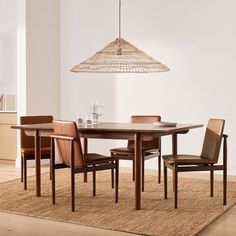 a dining room table with chairs and a light hanging from the ceiling in front of it