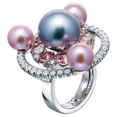 SORA by Ksenia Podnebesnaya presents an exquisite piece - a white gold ring that embodies the perfect harmony between spherical shapes and edges. At the heart of the ring is a magnificent 14.0 mm Tahitian pearl, its dark, lustrous surface so perfectly spherical and reflective that it appears to remain stationary as the ring is turned. This central pearl is complemented by three 9.0 mm freshwater pearls, all boasting a high luster and mirror-like surface that reflects surrounding gemstones. This interplay of pearl sizes and reflective qualities is further enhanced by 8 Malaya garnets totaling 5.01 carats, their color and cut adding depth to the design. The composition is completed by 36 round diamonds weighing a total of 1.32 carats in F/VVS2 grade, infusing the piece with brilliant sparkle Thai Modern, Katerina Perez, Round Diamond Setting, Art Jewelry Contemporary, Tahitian Pearls, Pearl Diamond, Contemporary Jewelry, Love Ring, Faceted Gemstones