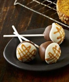 cake pops with caramel drizzled on them sitting on a black plate