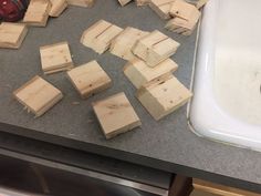 several pieces of wood sitting on top of a counter next to a sink and faucet