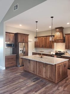 a large kitchen with wooden cabinets and an island in the middle of the room is shown