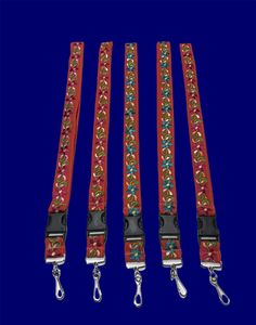 four red leashes with flowers on them are lined up against a dark blue background