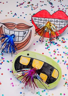 three different colored toothbrushes sitting on top of a table covered in confetti