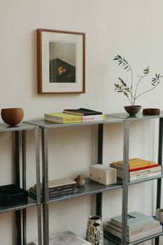 a metal shelf with books and vases on it