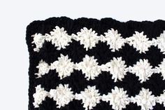 a black and white crocheted dishcloth with snowflakes on the side