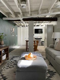 a living room filled with furniture and a flat screen tv mounted to the wall next to a wooden table