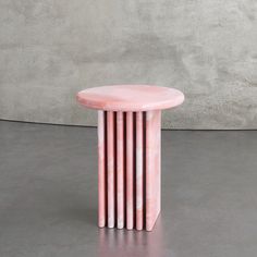 a pink marble table with four columns on it