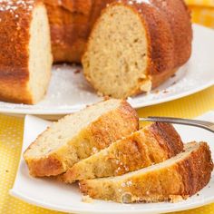 two white plates topped with slices of cake next to a loaf of bread on a yellow tablecloth