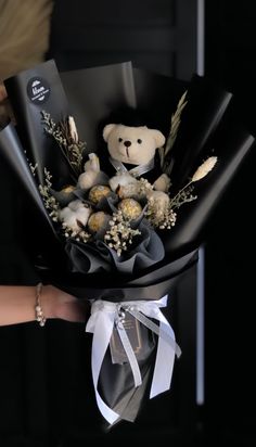 a person is holding a bouquet with flowers and a teddy bear