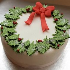 a decorated christmas cake with holly and red bow