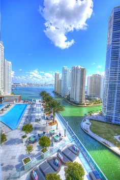 an aerial view of the pool and beach in front of some high rise buildings with green water