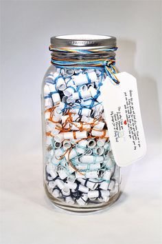 a glass jar filled with lots of white and blue beads