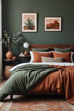 a bedroom with green walls, brown bedding and two pictures on the wall above it