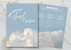 two wedding program booklets with clouds in the background