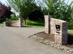 a brick entrance with two urinals on each side and trees in the background