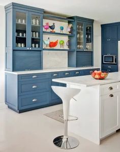 a kitchen with blue cabinets and white counter tops