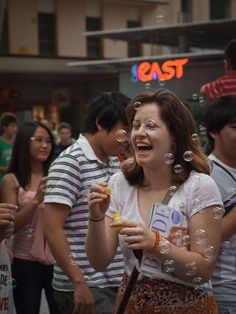 a woman is blowing bubbles in the air