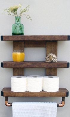 two wooden shelves holding toilet paper and a vase with flowers on it next to a wall mounted shelf