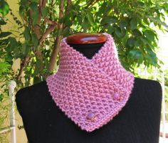 a pink crocheted cowl on a black mannequin in front of a tree