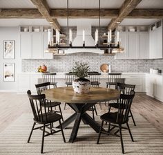 a large wooden table surrounded by black chairs in a white kitchen with exposed brick walls