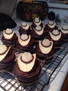 chocolate cupcakes with white frosting on a cooling rack