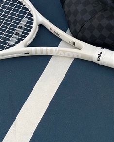 two tennis racquets laying next to each other on a blue and white surface