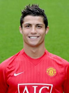 a young man in a red shirt is posing for a photo on the soccer field