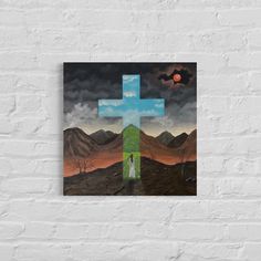 a painting on a brick wall with a cross in the middle and mountains behind it