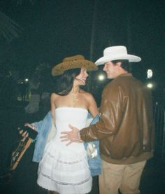 a man and woman dressed up in cowboy hats