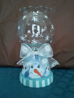 a clear glass bowl with snowflakes on it and a bow around the top