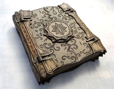 an intricately carved wooden book on a white tableclothed surface, with the cover partially closed