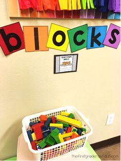 there is a basket full of blocks in front of a bulletin board with the word blocks on it