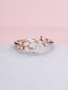 a gold ring with three leaves on it, sitting on top of a white surface