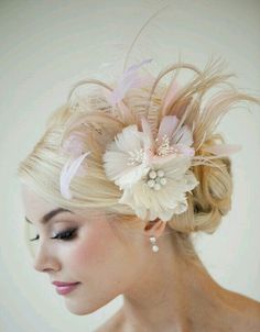 a woman with blonde hair wearing a pink flower and feather fascum headpiece