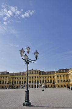 a lamp post in front of a large building with lots of lights on it's sides