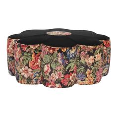 a round ottoman with floral print on the top and black fabric around it, sitting in front of a white background