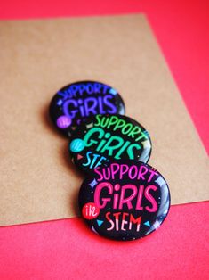 three badges that say support girls on them